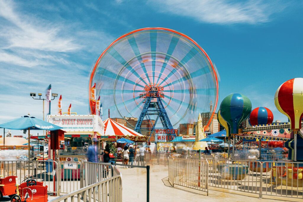 Vibrant scene of Ferris wheel and attractions at Coney Island, New York.